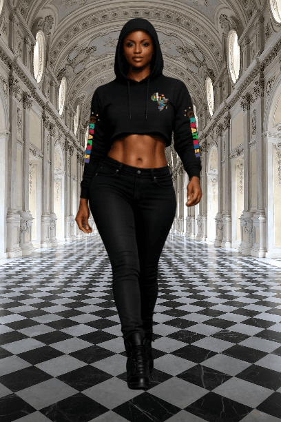 Woman in a black cropped hoodie walking through a grand hall with checkered floors.